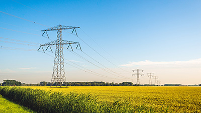 Elledningar, rapsfält, blå himmel