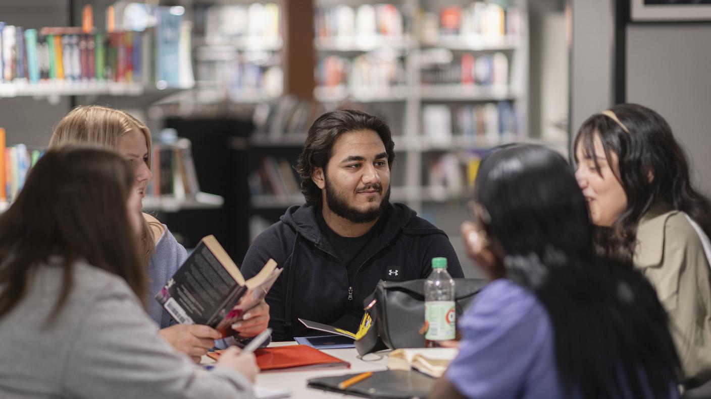 Ungdomar samtalar runt ett bord på biblioteket hos Tegelbruket i Örebro