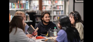 Ungdomar samtalar runt ett bord på biblioteket hos Tegelbruket i Örebro