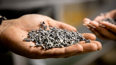 kupade händer som håller i granulerad plast