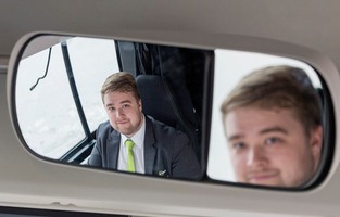 Bussförare kikar bakåt i backspegeln