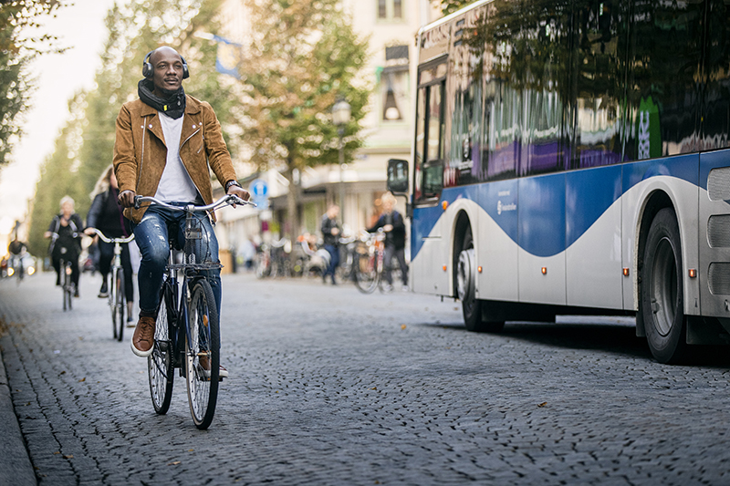 Cyklist på Drottninggatan i Örebro. En buss passerar i motsatt riktning.