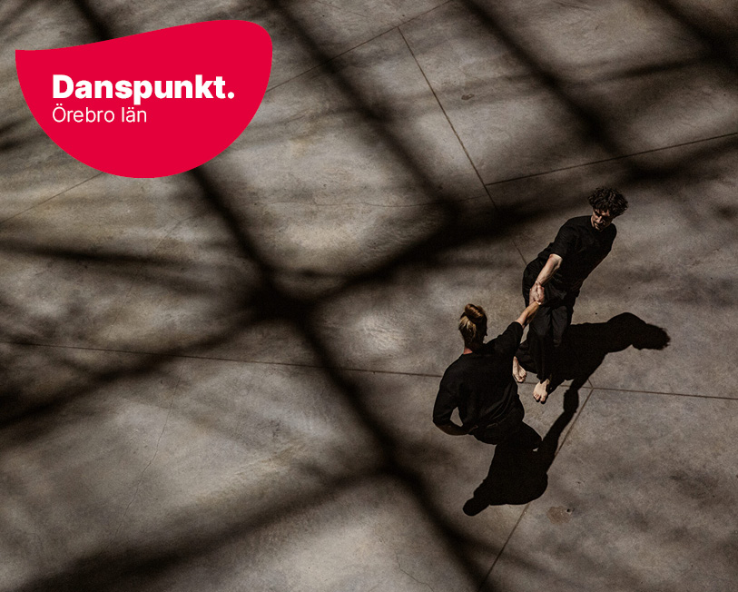 Två dansare uppifrån under dramatiska skuggor