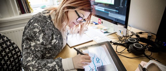 Konstnär arbetar med en barnteckning på digital ritplatta