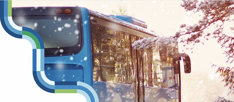 En buss och snöiga granar. Länstrafikens dekorelement i kanten av bilden