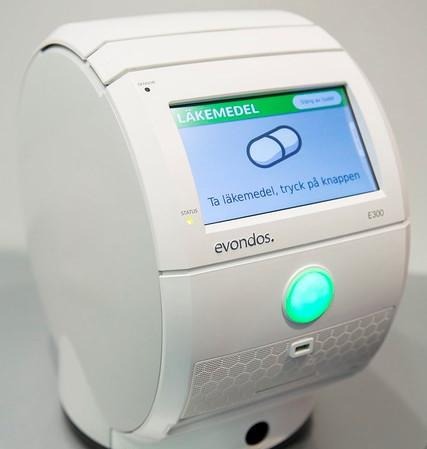 en bullig vit maskin som har en display i blått och en grön lysande knapp under displayen