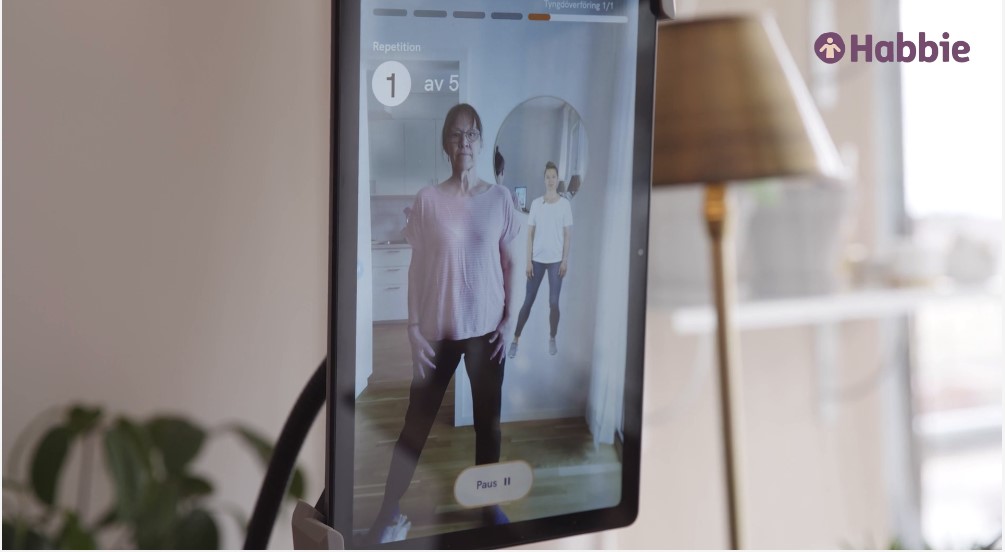 En digital skärm som visar en kvinna i träningskläder