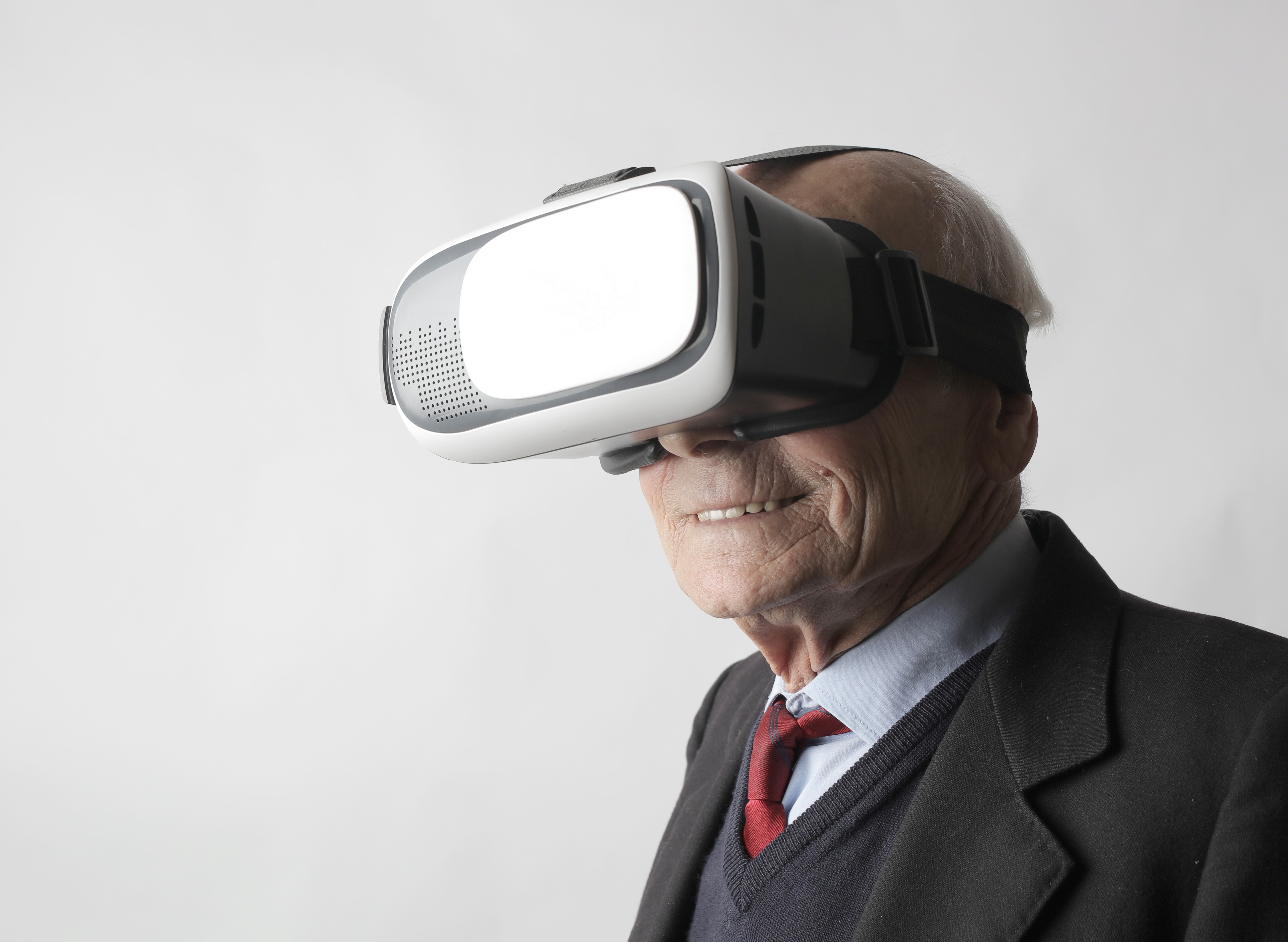 Äldre gråhårig man med VR-glasögon på sig